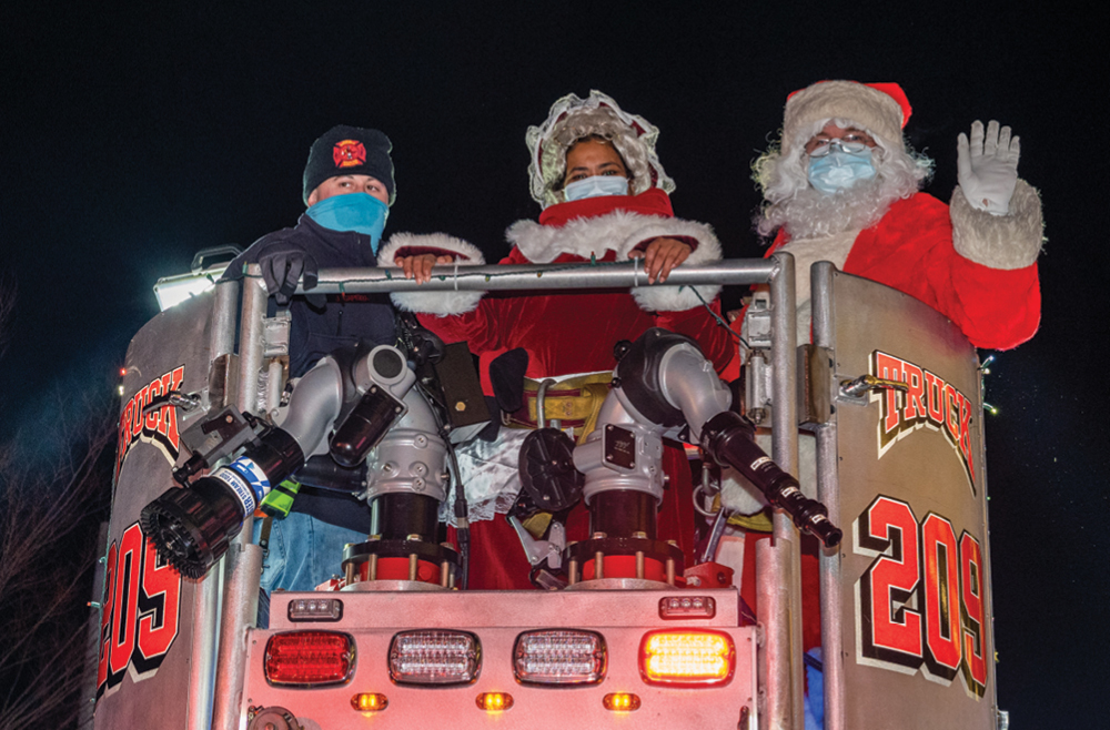 Santa Claus and his helpers on a fire truck